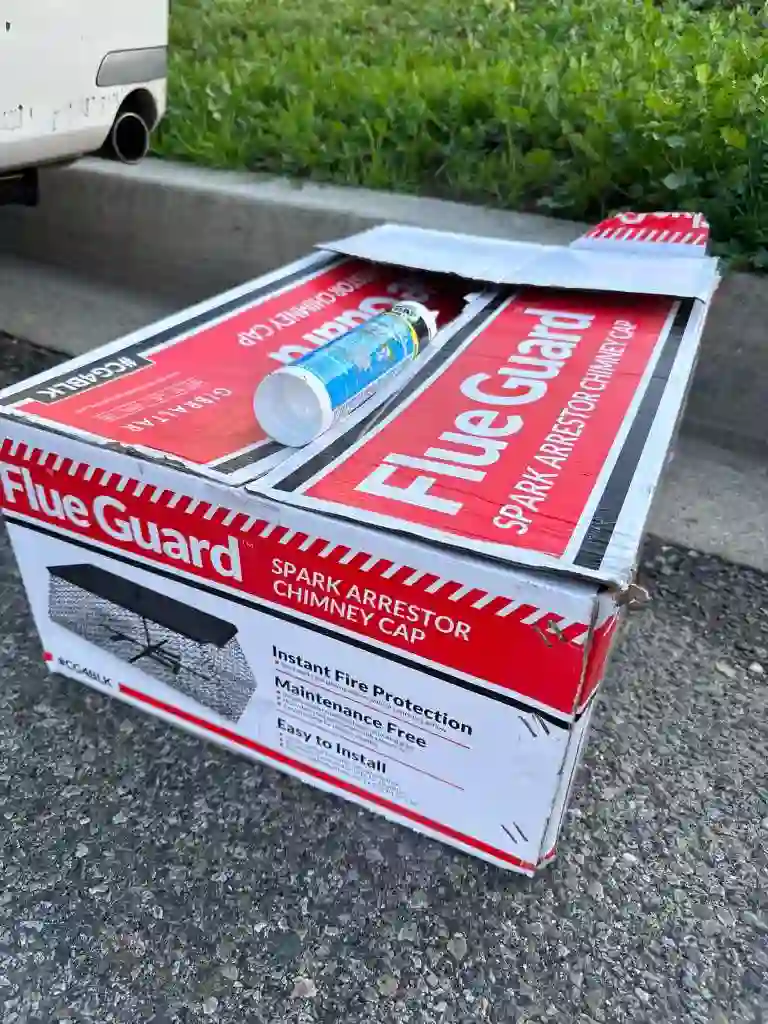 New spark-arrestor chimney cap in its box on a job site, ready to install