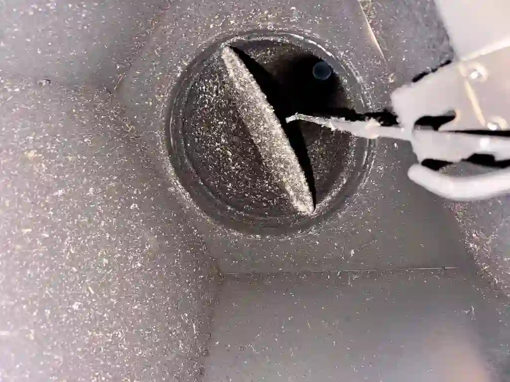 Looking up a chimney flue at a soot-covered damper during cleaning