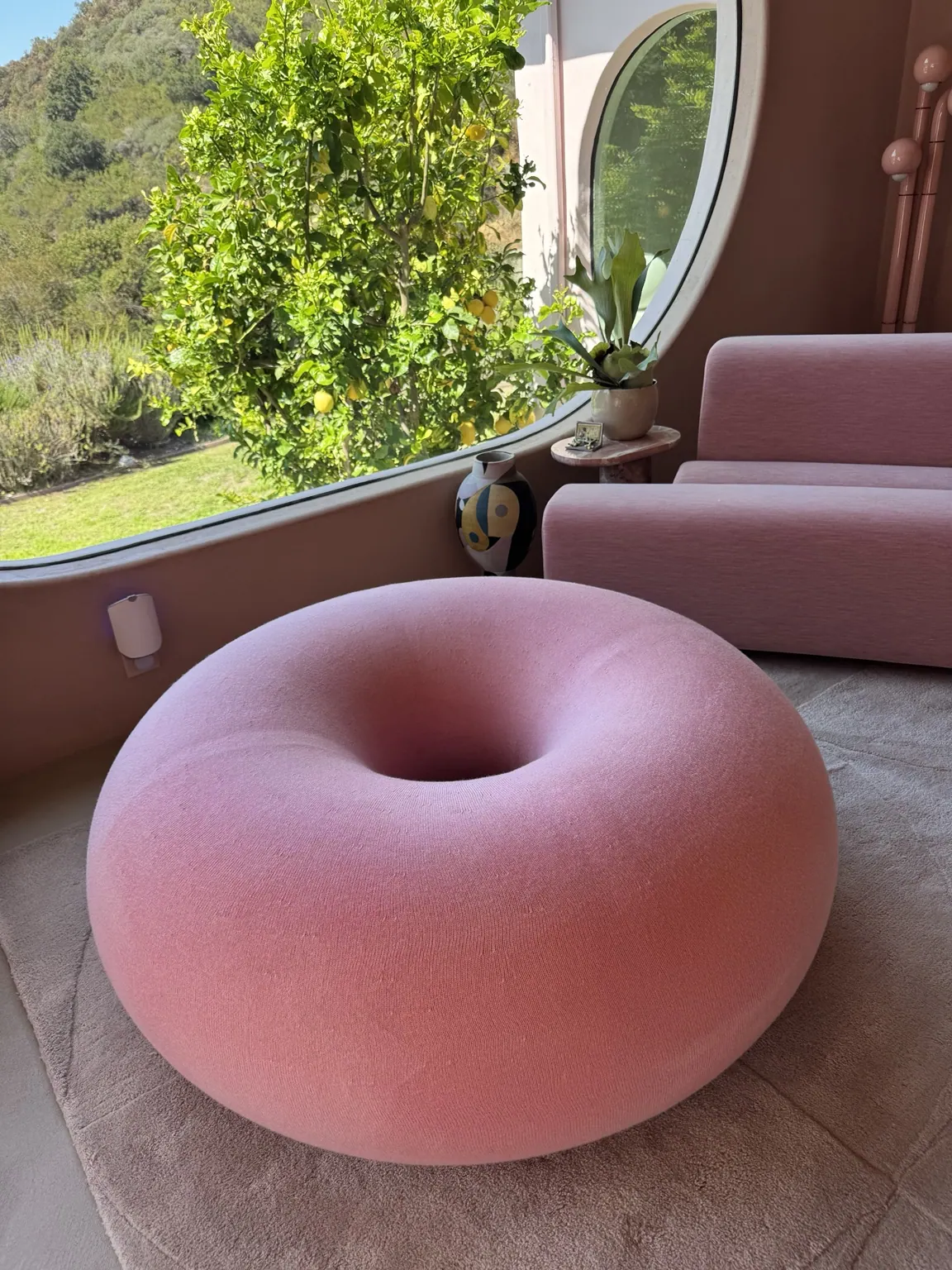 Pink upholstered pouf cleaned in a sitting room