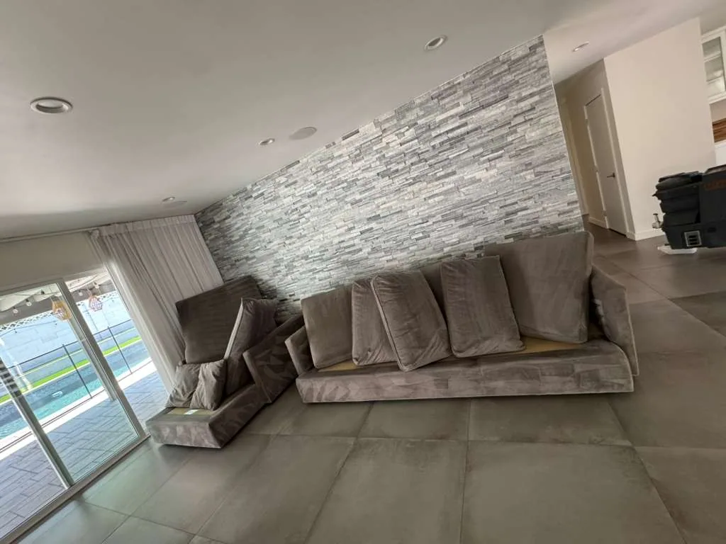 Gray sectional with cushions removed and set out for upholstery cleaning