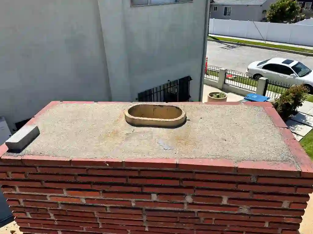 Open chimney flue on a brick chimney crown with the cap removed