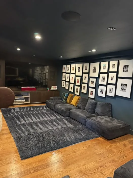 Gray area rug on hardwood in a dark-walled living room after cleaning