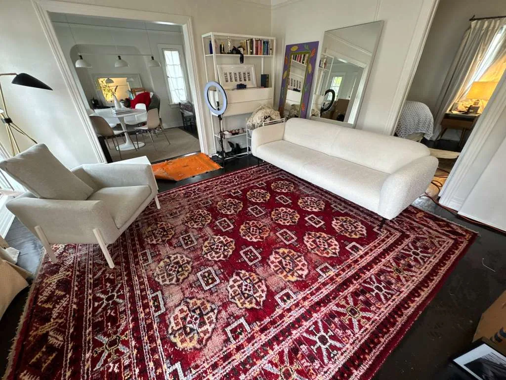 Cream boucle sofa and armchair cleaned in a living room with a red patterned rug