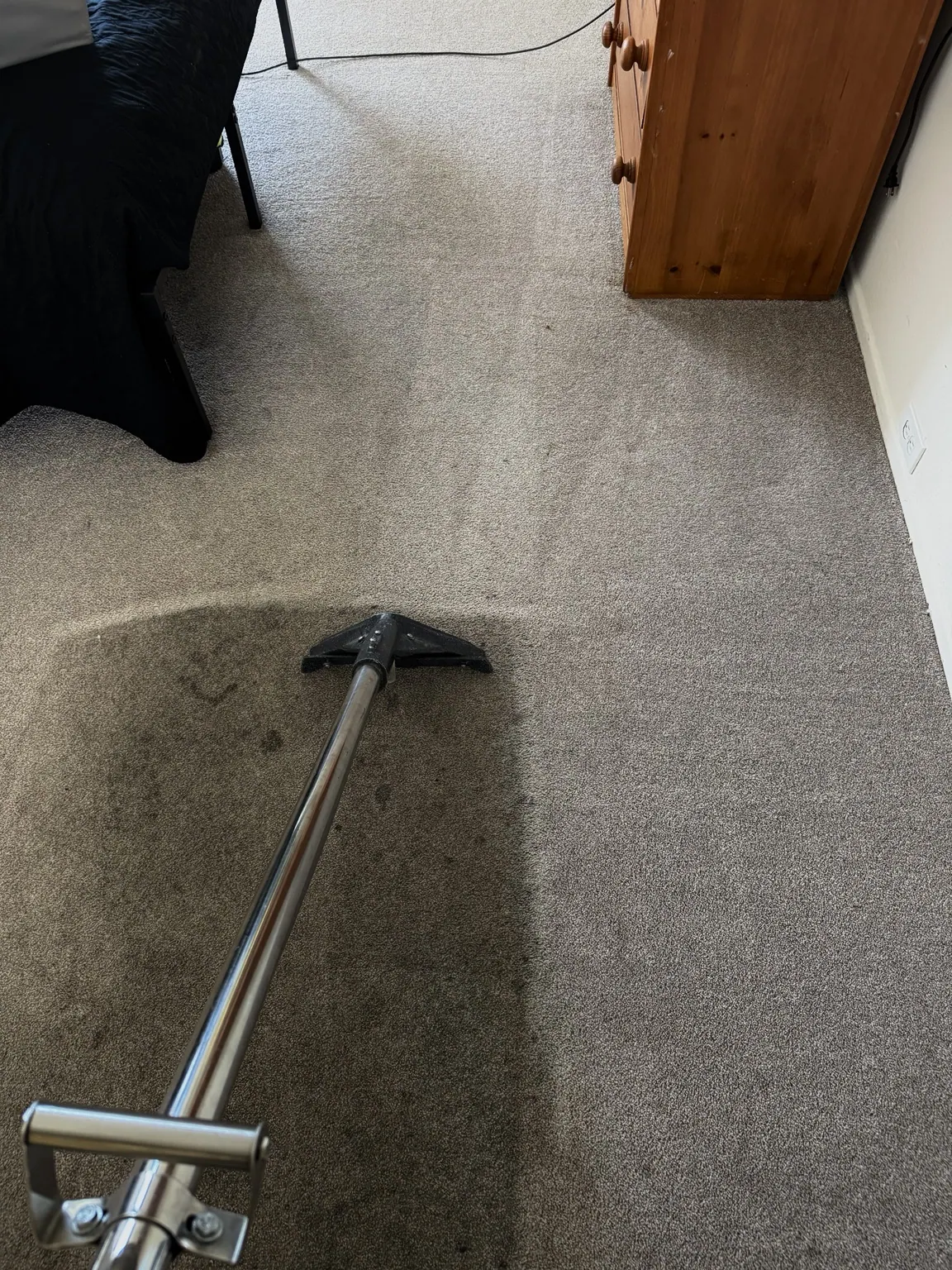 Cleaning wand on bedroom carpet mid-job
